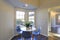 Lovely breakfast nook with white round table and blue chairs.