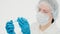 Lovely caucasian female scientist in laboratory puts a blue faci