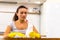 Lovely caucasian lady is bored of cleaning day after day and she sits at the table, with rag and spray on it, looking