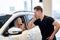 lovely caucasian woman begs boyfriend to buy auto in car showroom. In Auto In Dealership