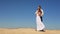 Lovely cheerful couple of newlyweds is tenderly hugging on the sand beach over the blue sky in Egypt.