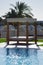 Lovely close-up of a beach sunbath shelter with sparkling water surface in the bottom of the image