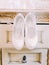 The lovely composition of the white wedding high heels shoes placed on the wardrobe.