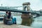 Lovely cople sitting on the beach and lookin at bridge