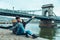 Lovely cople sitting on the beach and taking selfie bridge on background