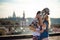 Lovely couple of active skateboarders embrace and kiss passionately, hide themselves behind skateboard, stand against