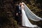 Lovely couple - bride and groom hugging and kiss in a beautiful mystery forest.