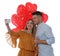 Lovely couple with heart shaped balloons taking selfie on white background. Valentine`s day celebration