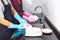 Lovely couple is helping each other for cleaning dishes on sink