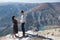 Lovely couple joins hands standing on edge of rocky cliff