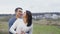 Lovely couple stands in softly embraces on the cliff of the mountain