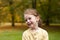 Lovely cute red-haired little girl in the autumn park outdoors. Lovely baby in front of falling leaves