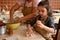 Lovely daughter in chef apron, kneading dough on a kitchen table, cooking homemade pastries, pie, tartlets with her mom.