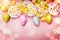 Lovely Easter setting in pastel color with decoration eggs, flowers,cakes and bokeh lighting on pink pale background, top view
