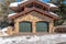 Lovely facade of home in Park City Utah with two green arched garage doors