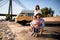 Lovely family couple with small child is resting on the sandy river bank