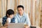 Lovely father and son are helping to design a wooden house with a laptop