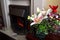 Lovely festive Christmas flower arrangement with lilies and carnations, fireplace in background, copy space for text