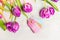 Lovely fresh tulips with empty tags on light shabby chic background, top view. Spring flowers
