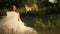 Lovely gentle blonde bride dancing in a wheat field in white bridal dress