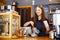 Lovely girl barista folds gingerbread in a package in a coffee house