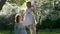 Lovely girl in dress kiss mother stand on swings in blossom garden. Slow motion