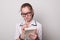 Lovely girl in glasses with a notebook. Young girl holds a notebook and pen.