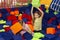 Lovely girl and her mom having lots of fun playing with soft cubes at indoor kids centre, copy space