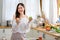 Lovely girl hold green and red apple and smile in kitchen with morning light and look happy. Concept of healthy food help and