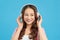 Lovely girl listening a music in headphones, blue background