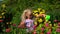 Lovely girl with plastic watering can waters flowers in summer garden