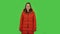 Lovely girl in a red down jacket is smiling while looking at camera . Green screen