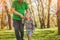 Lovely girl walking with grandfather in park