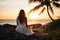 Lovely graceful lady sit by beach at sunset with beautiful seascape.