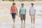 Lovely group of three senior mature retired women on their 60s having fun enjoying together happy walking on the beach smiling pla