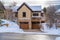 Lovely house facade with attached two car garage snowy gable roof and balcony