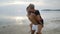 Lovely Interracial couple piggyback ride and kissing at the beach at sunset