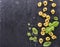 Lovely Italian tortellini with fresh basil leaves, sea salt, pepper peas on a black stone board.