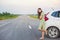 lovely lady dressed in a beautiful dress stands by a car, enjoying a pleasant summer day. The concept of vacati