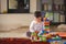 Lovely laughing little child, brunette girl of preschool age playing with colorful blocks sitting on a floor