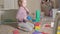 Lovely laughing little kid, preschool blonde, playing with colorful toys, sitting on the floor in the room