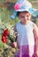 Lovely little girl in the field of wild flowers