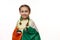 Lovely little girl with funny pigtails, posing wrapped in Ireland flag on isolated white background. Saint Patrick's
