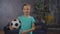 Lovely little girl posing with soccer ball indoor