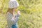 Lovely little girl smelling flowers in garden