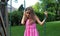 Lovely little girl at swings in the park with pink dress during summer in Michigan