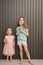 Lovely little girls with lollypop on gray background