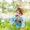 Lovely little kid boy with Easter bunny ears celebrating traditional feast. Happy child eating chocolate rabbit fugure