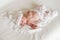 Lovely newborn age of 2 weeks in white knitted hat