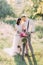 Lovely photo of the bride in the wedding white dress and modern-dressed groom carrying the bicycle in the middle of the